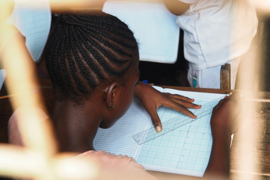 A learner studying with notebooks and study tools